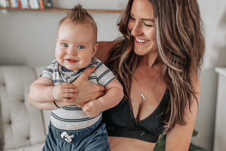 Gen Z parent cradling her happy infant—an authentic image of modern motherhood for brands targeting Gen Z moms.
